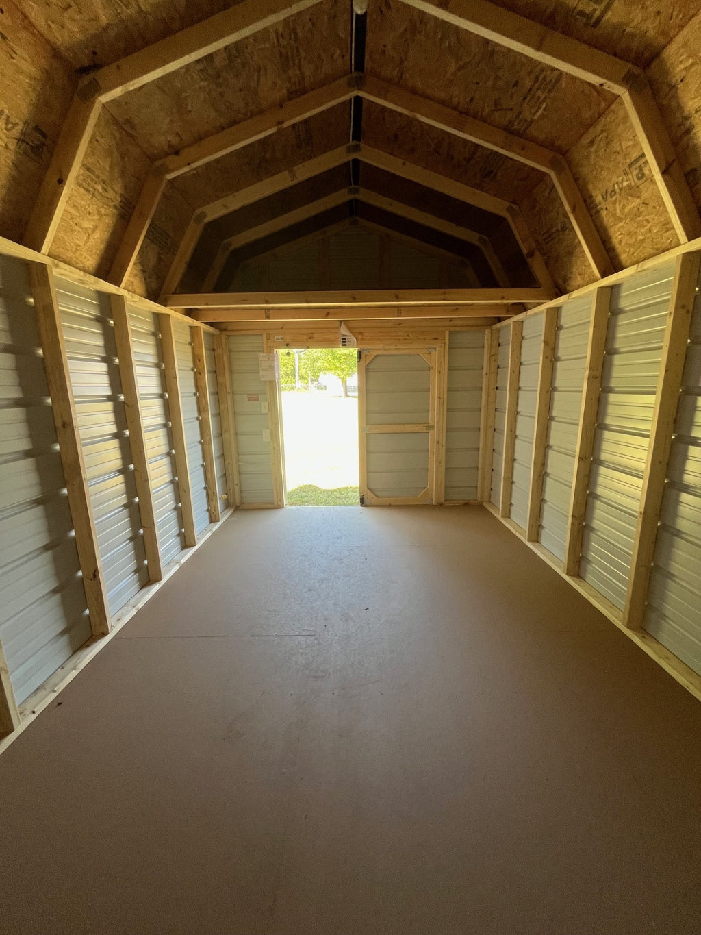 Outland Trailers 10x16 metal lofted barn with steel roof, side door, and vented windows for durable outdoor storage.