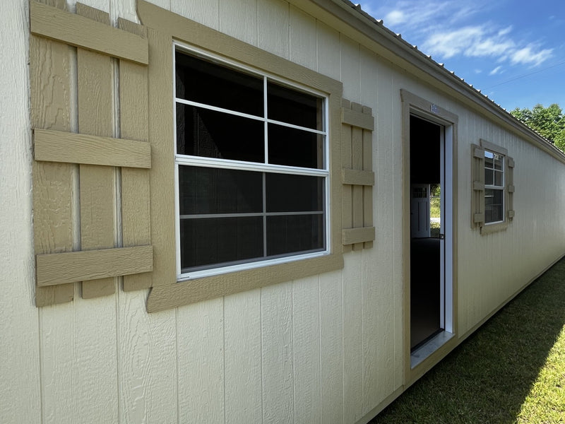 Outland Trailers 14x40 tiny home shell with wooden exterior and large windows, ready for customization and interior finishing.