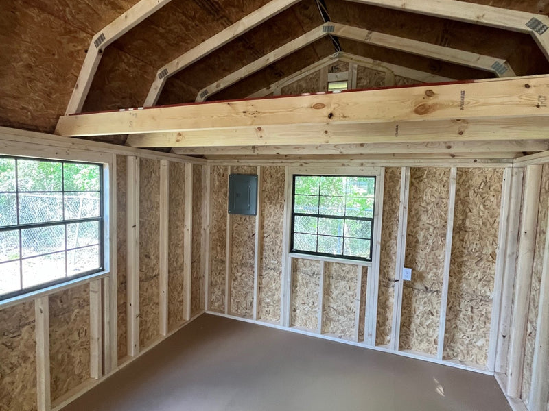 Outland Trailers 12x32 lofted barn cabin with raised roof, windows, and wooden exterior, showcasing a sturdy outdoor structure.