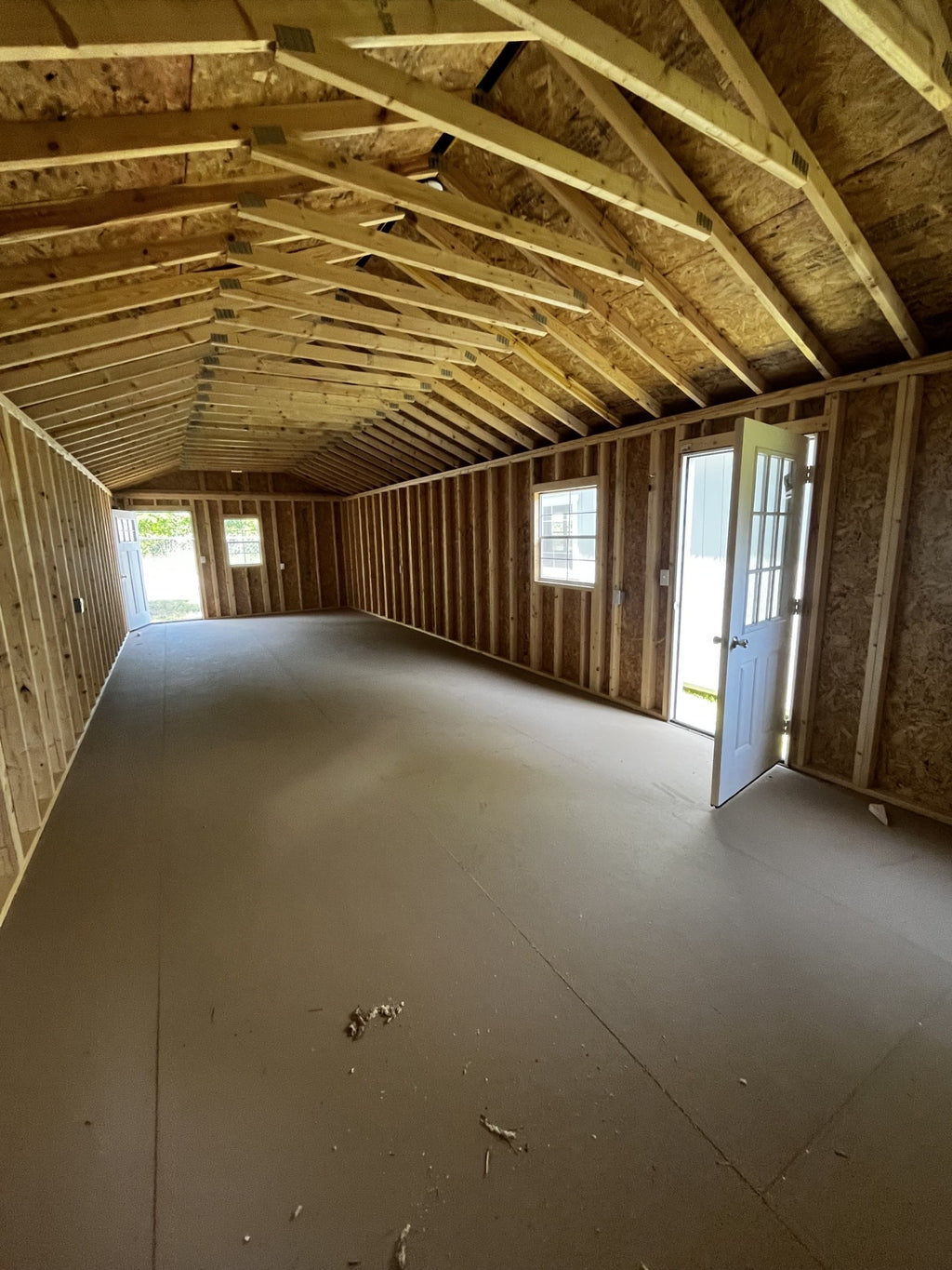 Outland Trailers 14x40 tiny home shell showing wooden exterior walls and door framing for compact, portable living space.