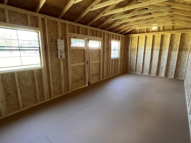 Outland Trailers 12x24 side utility shed with metal walls and door, outdoor storage solution in a backyard setting