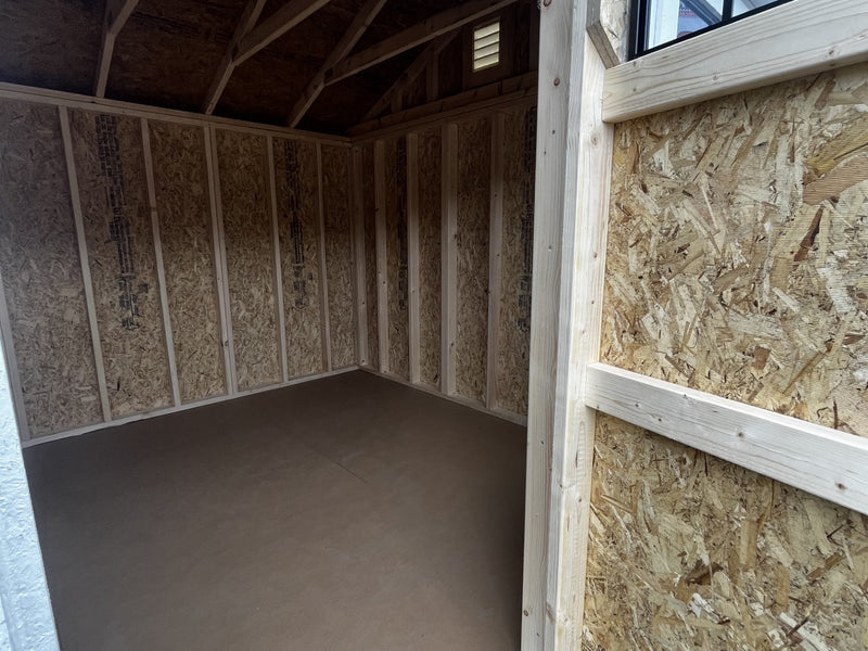 Outland Trailers 10x16 garden shed with double doors and window, made of durable wood for outdoor storage and organization.