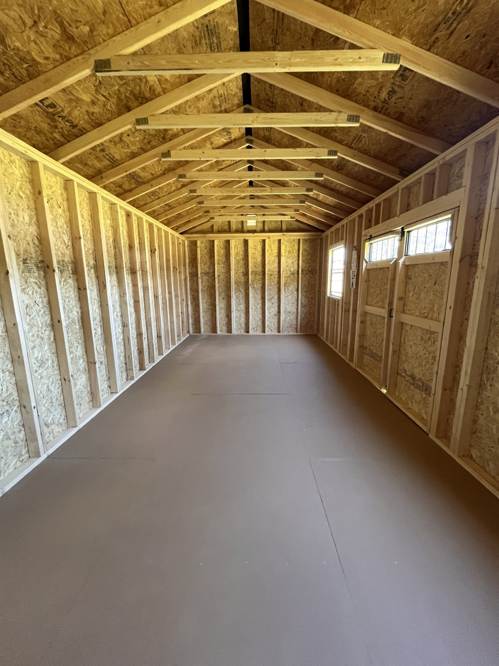 Outland Trailers 12x24 side utility shed with double doors and metal exterior, ideal for storage and outdoor use.