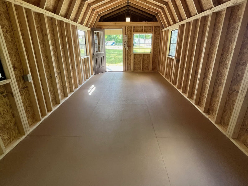 Outland Trailers 12x32 lofted barn cabin with wooden exterior, large windows, and lofted roof, suitable for storage or rustic retreat.
