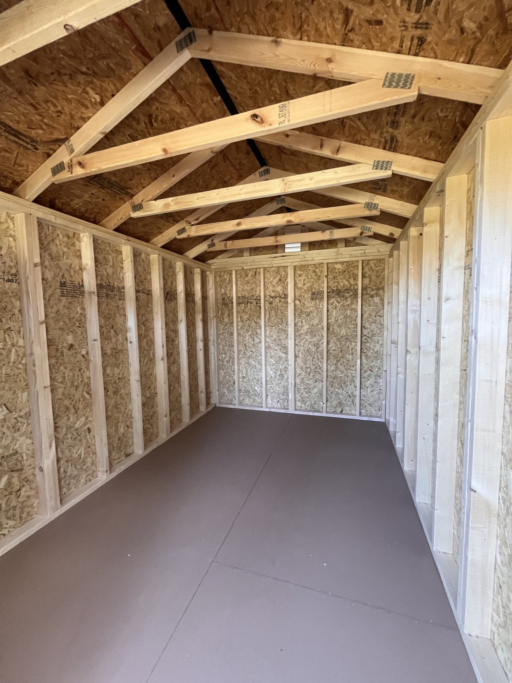 Outland Trailers 8x12 garden shed with double doors and window, made of durable weather-resistant materials.