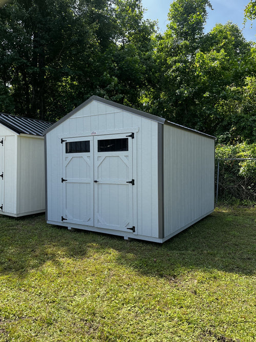 Outland Trailers 10x12 utility shed with metal walls and door, outdoor storage solution for gardening tools and equipment.