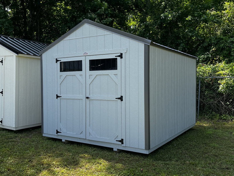 Outland Trailers 10x12 utility shed with metal walls and door, outdoor storage solution for gardening tools and equipment.