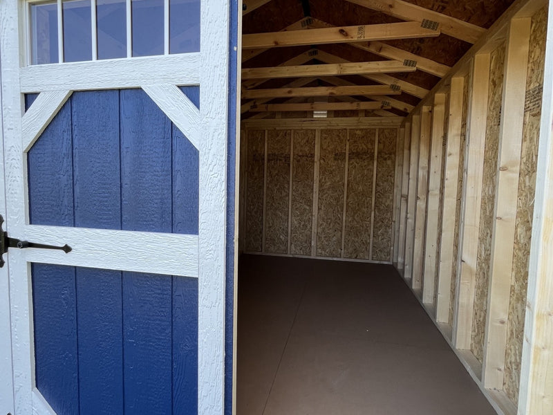 Outland Trailers 8x12 garden shed with double doors and weather-resistant wood exterior for outdoor storage.