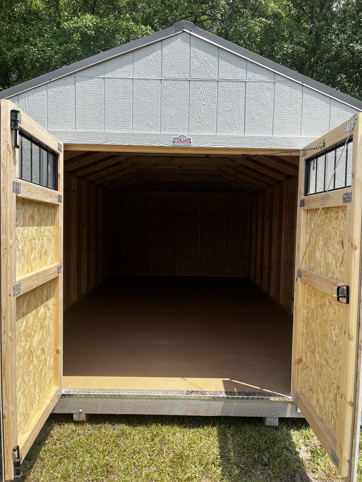 Outland Trailers 12x20 utility shed showing a sturdy metal building with double doors and a sloped roof for outdoor storage