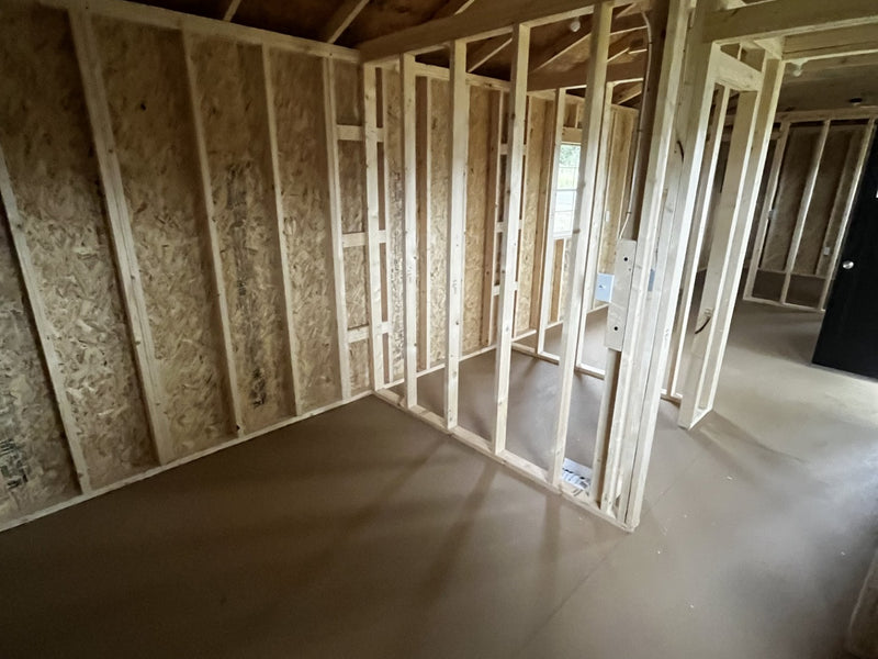 Outland Trailers 12x36 tiny home shell with wooden exterior walls and large front window, ready for customization.