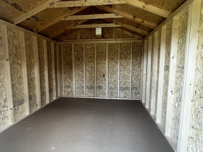 Outland Trailers 10x12 utility shed with metal roof and double doors, ideal for storage and outdoor equipment.