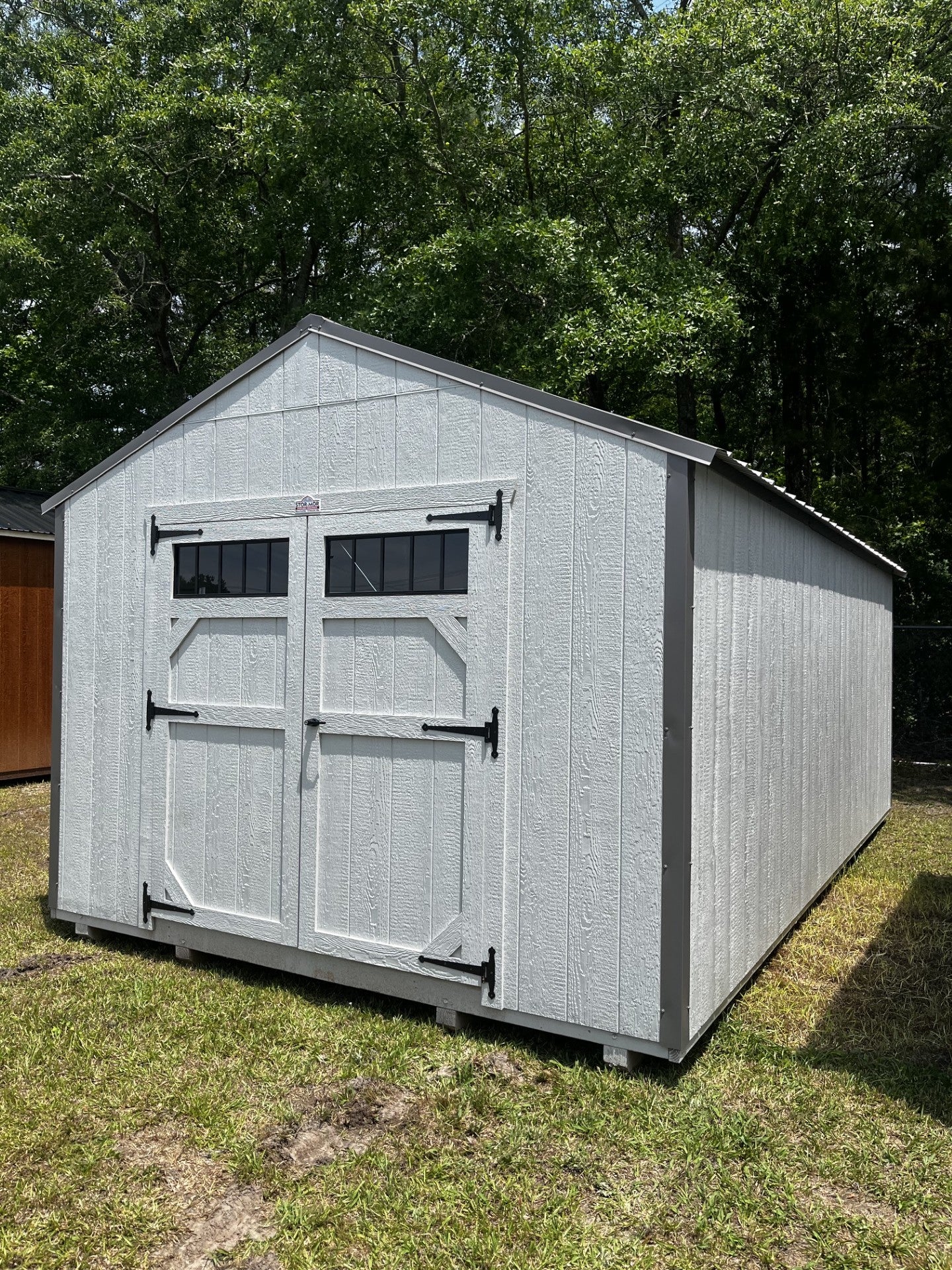 Outland Trailers 12x20 utility shed shown outdoors with double doors and durable metal construction.