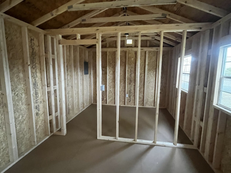 Outland Trailers 12x36 tiny home shell with wooden exterior, large window and door opening, ready for customization and interior finishing.