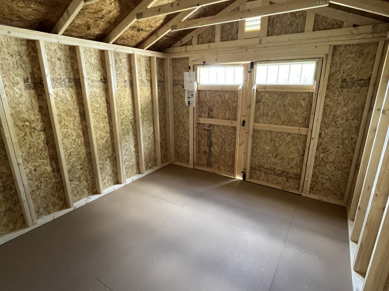 Outland Trailers 10x12 garden shed with double doors, weather-resistant construction, and sturdy wooden panels for outdoor storage.