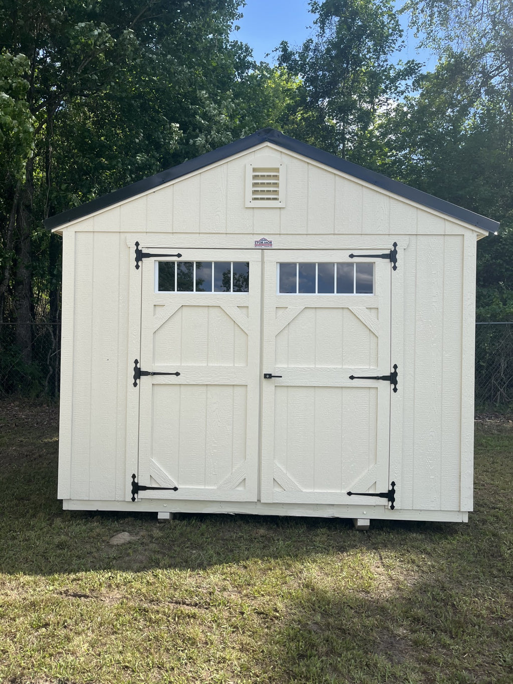Outland Trailers 10x12 garden shed with double doors and shingle roof, ideal for outdoor storage and garden tools