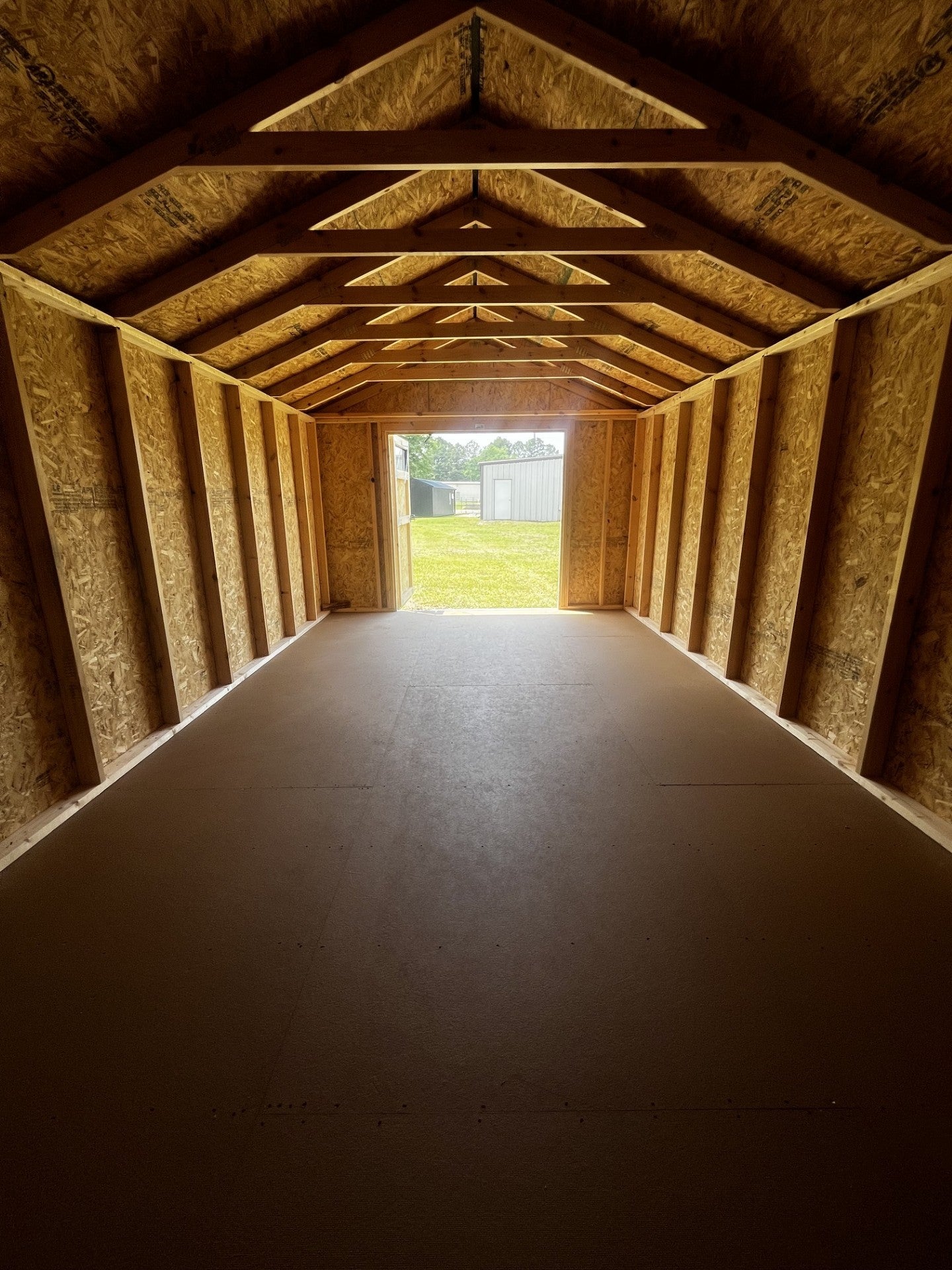 Outland Trailers 12x20 utility shed with durable metal construction and side door for storage and organization.
