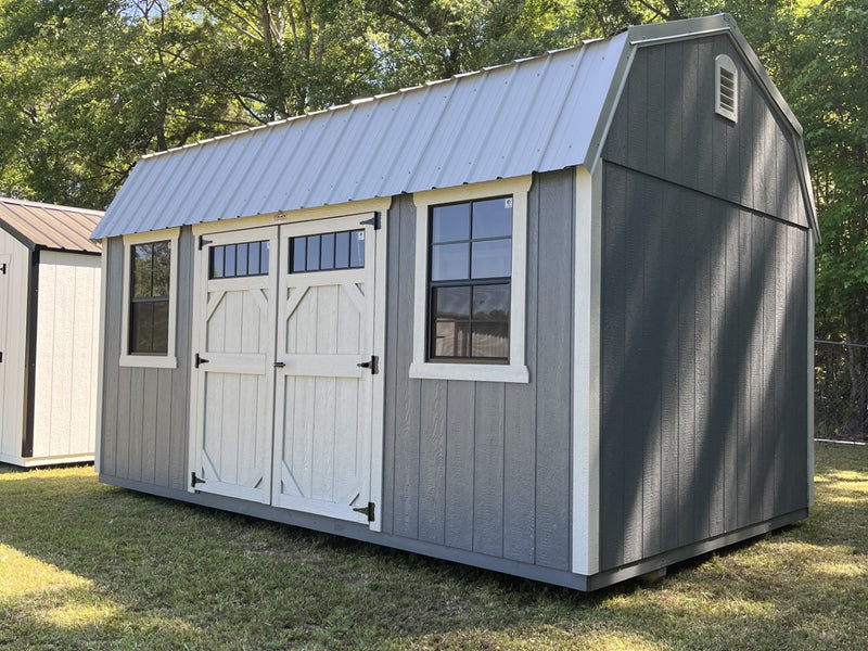 Outland Trailers 10x16 side lofted barn with wooden walls, side door, and lofted roof, suitable for storage or workshop use.