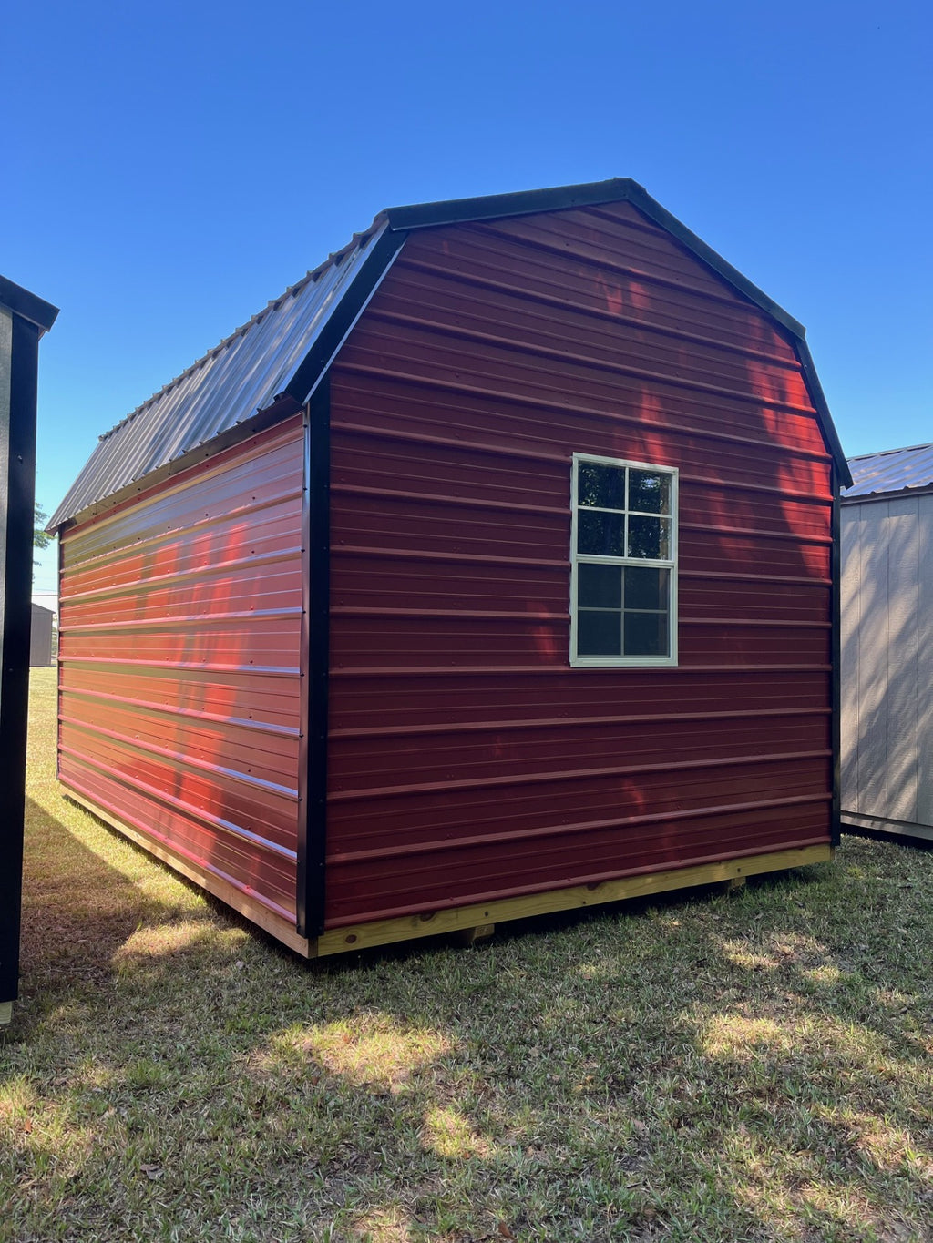 Metal lofted barn by Outland Trailers featuring a gray steel exterior, lofted storage space, and sturdy construction.
