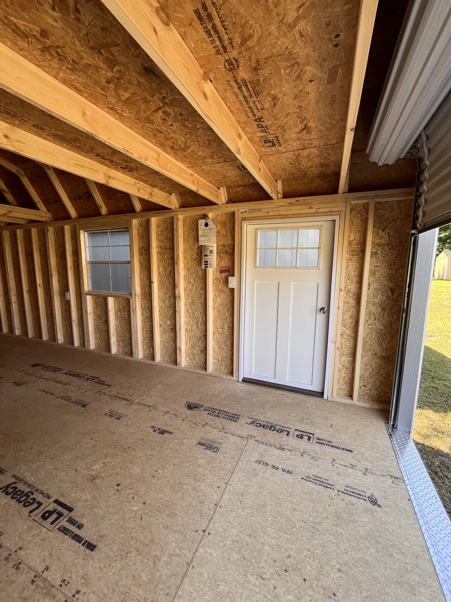 Outland Trailers 12x24 lofted garage with metal walls, windows, and a pitched roof for storage or workshop use.