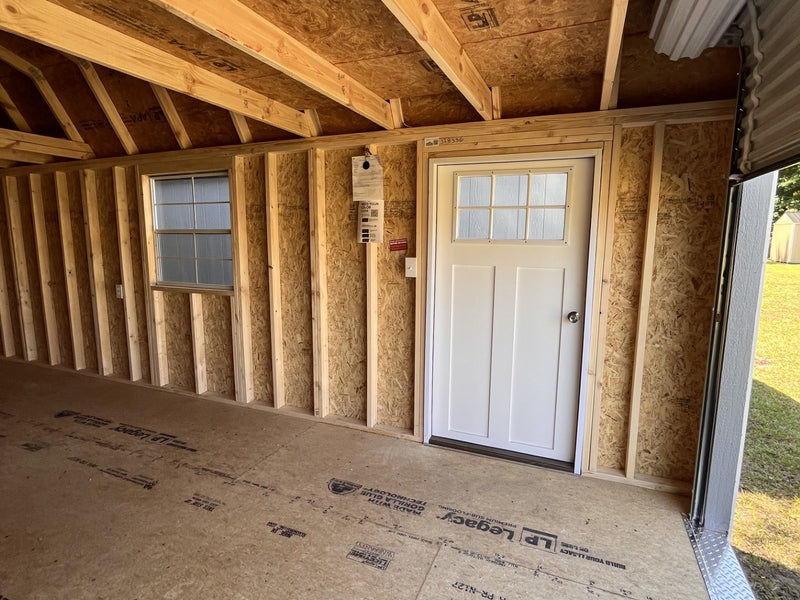 Outland Trailers 12x24 lofted garage with metal walls, windows, and a pitched roof for storage or workshop use.