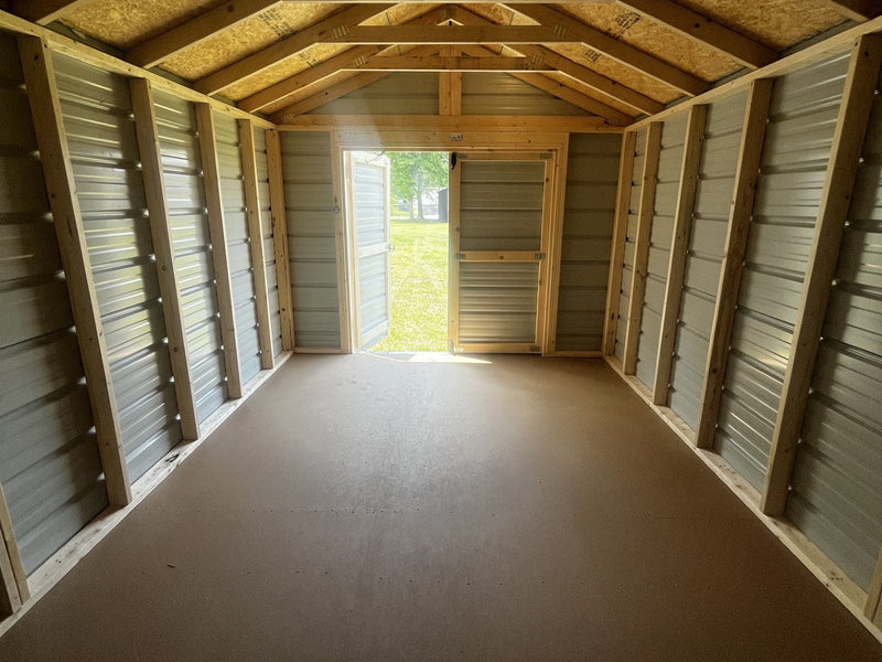 Outland Trailers 10x16 metal utility shed with double doors and vented roof, ideal for outdoor storage and garden tools.