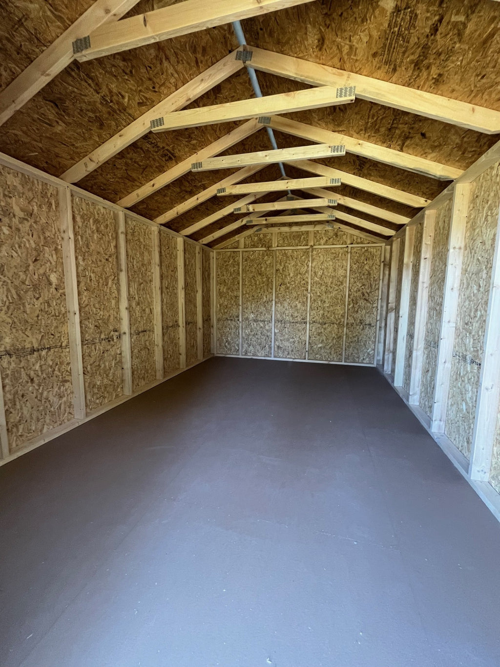 Outland Trailers 10x16 Tru-Valu Utility Shed with metal walls and door, outdoor storage solution, portable and durable construction.