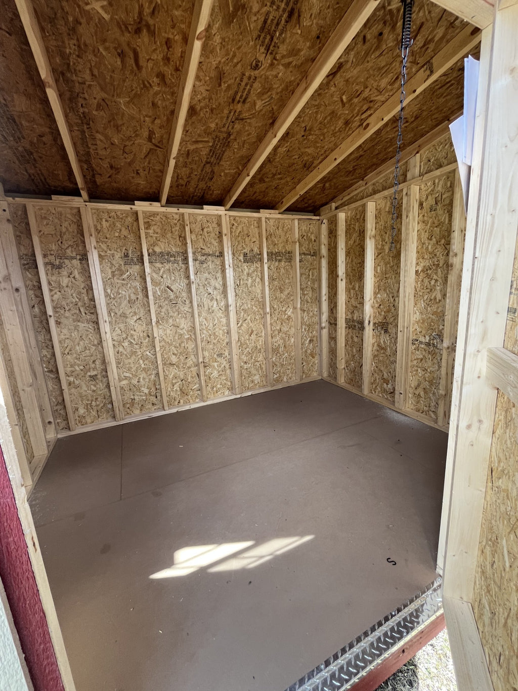 Outland Trailers 8x10 cottage shed with wooden exterior and sloped roof, ideal for storage or garden use.