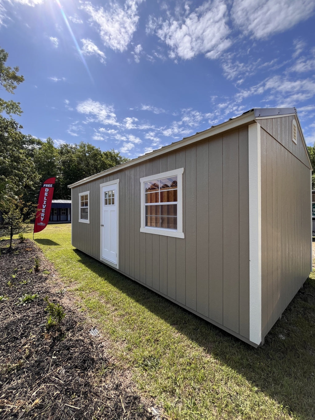 Outland Trailers 12x24 garage with metal walls and roof, large double doors, and side window for storage and workshop space.