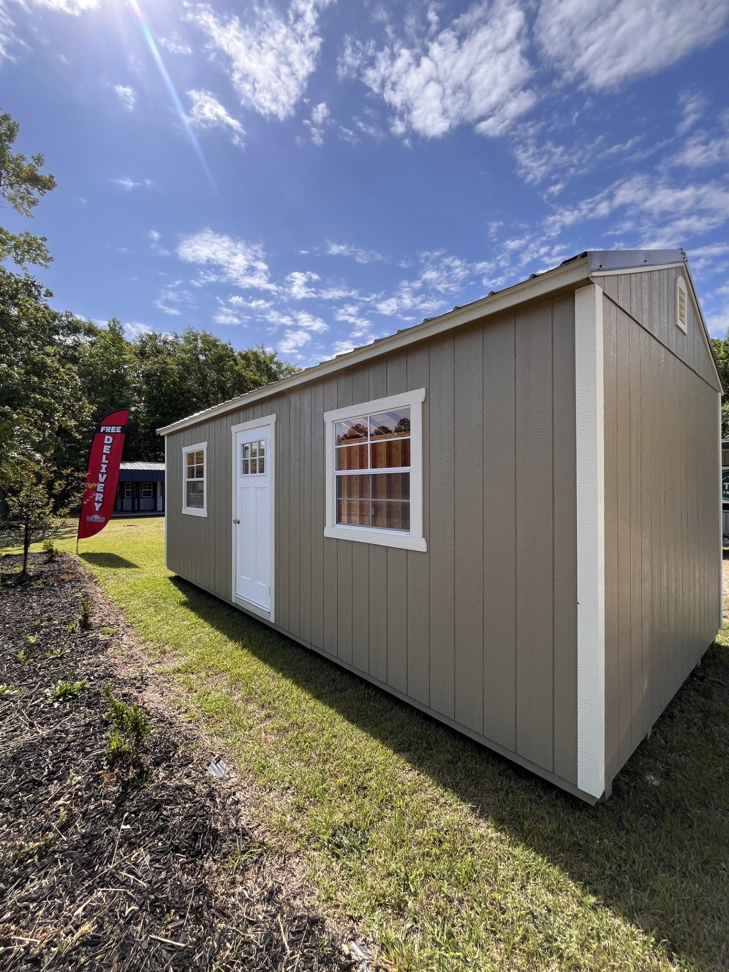 Outland Trailers 12x24 garage with metal walls and roof, large double doors, and side window for storage and workshop space.
