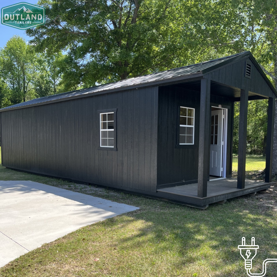 Outland Trailers 12x36 cabin trailer with wooden exterior and metal frame, ideal for camping or mobile tiny home use.