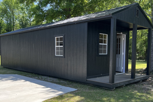 Outland Trailers 12x36 cabin trailer with wooden exterior and metal frame, ideal for camping or mobile tiny home use.