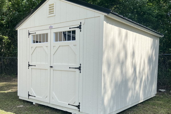 Outland Trailers 10x12 garden shed with double doors and window for outdoor storage and gardening tools.