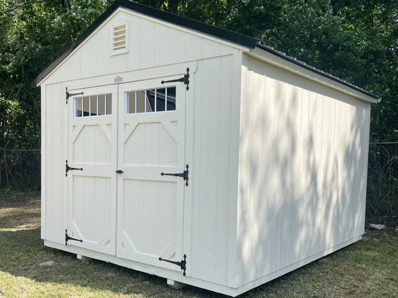 Outland Trailers 10x12 garden shed with double doors and window for outdoor storage and gardening tools.