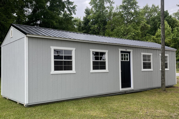 Outland Trailers 12x36 tiny home shell with wooden exterior walls and roof, ready for customization and interior finishing.