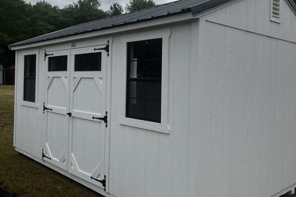 Outland Trailers 10x16 garden shed with white walls and gray roof, featuring double doors and window for outdoor storage.