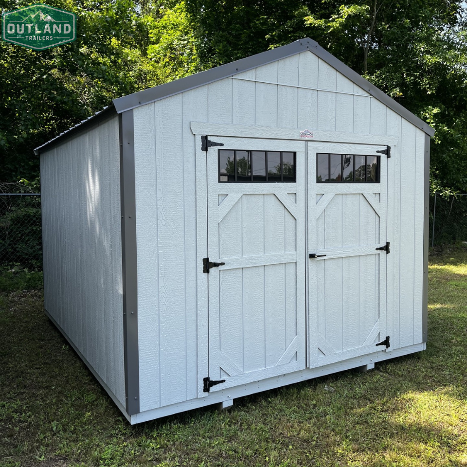 Outland Trailers 10x12 utility shed with sturdy metal construction and overhang for storage and outdoor organization.