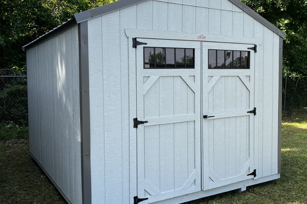 Outland Trailers 10x12 utility shed with sturdy metal construction and overhang for storage and outdoor organization.