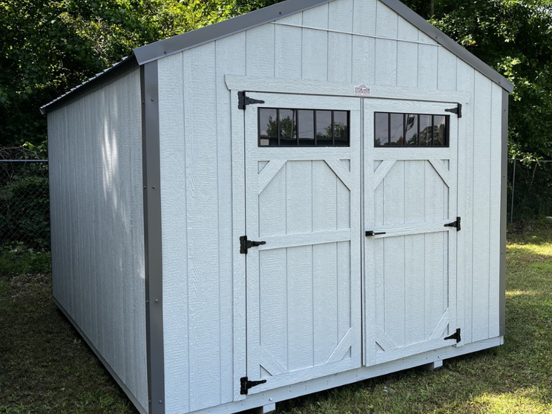 Outland Trailers 10x12 utility shed with sturdy metal construction and overhang for storage and outdoor organization.