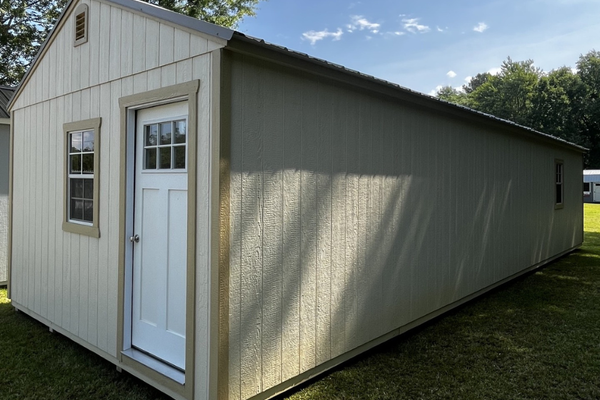 Outland Trailers 14x40 tiny home shell with wooden exterior walls and windows, ready for customization and interior finishing.