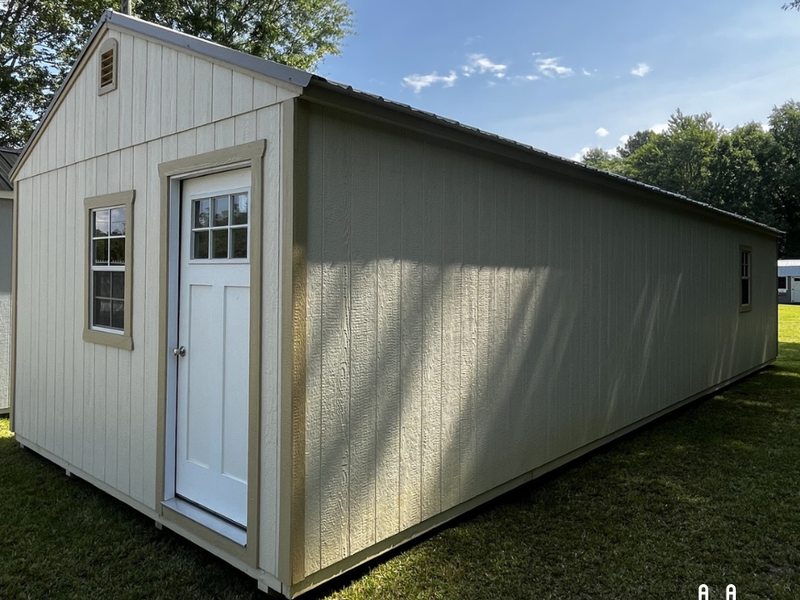 Outland Trailers 14x40 tiny home shell with wooden exterior walls and windows, ready for customization and interior finishing.