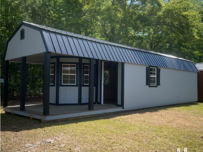 Outland Trailers 12x40 Deluxe Lofted Barn with wooden exterior and lofted storage design, ideal for storage or workshop use.