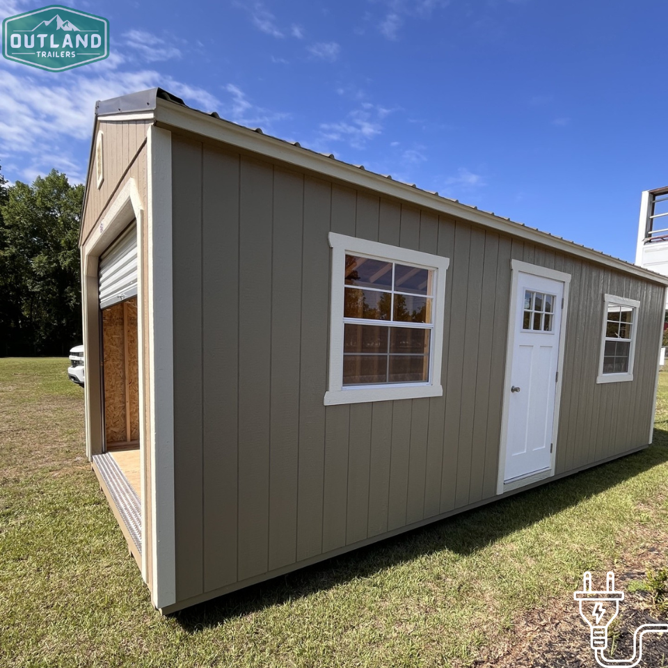Outland Trailers 12x24 garage shed with metal roof, side door, and sturdy construction, ideal for storage or workshop use.