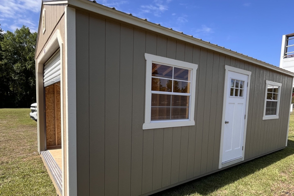 Outland Trailers 12x24 garage shed with metal roof, side door, and sturdy construction, ideal for storage or workshop use.
