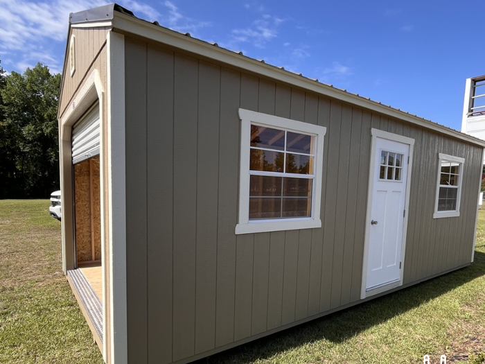 Outland Trailers 12x24 garage shed with metal roof, side door, and sturdy construction, ideal for storage or workshop use.