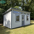 Outland Trailers 10x20 sloped studio, metal shed with sloped roof, double doors, and windows, ideal for storage or workspace.