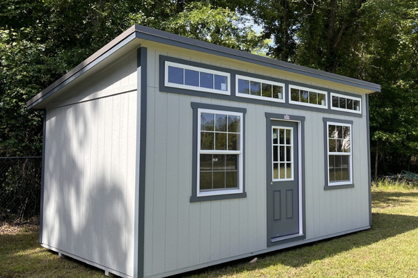 Outland Trailers 10x20 sloped studio, metal shed with sloped roof, double doors, and windows, ideal for storage or workspace.