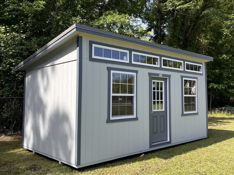 Outland Trailers 10x20 sloped studio, metal shed with sloped roof, double doors, and windows, ideal for storage or workspace.