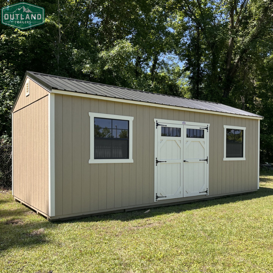 Outland Trailers 12x24 side utility shed with double doors and durable metal construction in a natural outdoor setting.