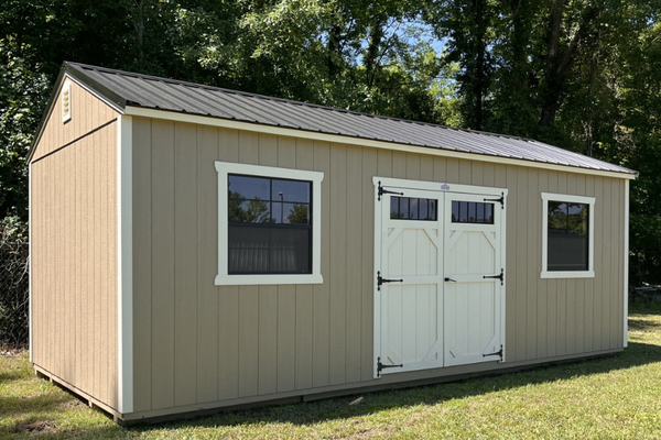 Outland Trailers 12x24 side utility shed with double doors and durable metal construction in a natural outdoor setting.