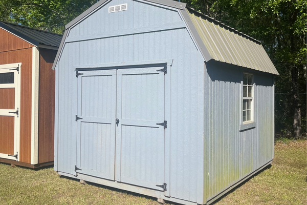 Used 10x12 lofted barn by Outland Trailers, showing the wooden structure with raised loft area and sturdy construction.